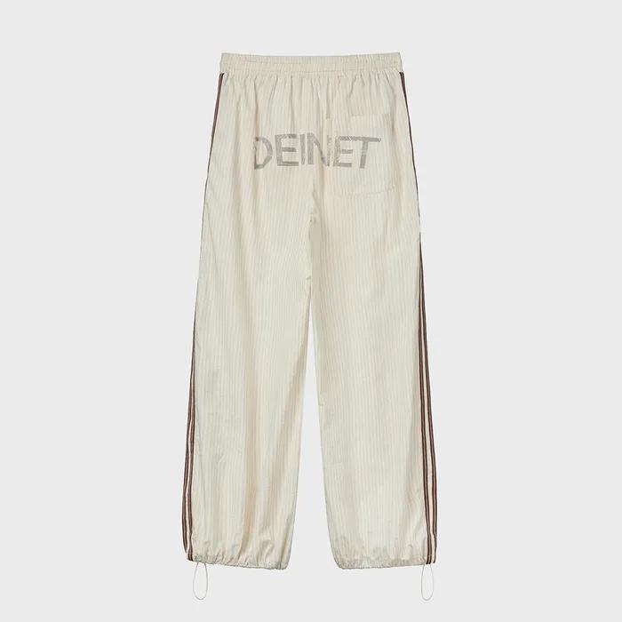 DEINET BACK LOGO BANDING PANTS IN BEIGE