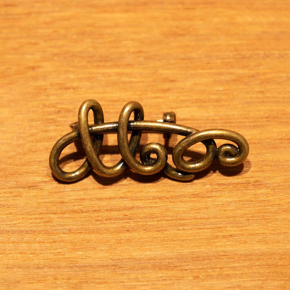 TWISTED LOGO BADGE-GOLD BRASS